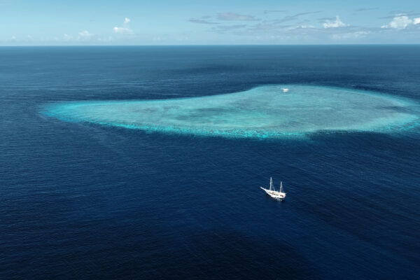 Vue aérienne d'un bateau de croisière plongée au-dessus du récif de Karang Hatta, dans les îles Banda, en Indonésie.